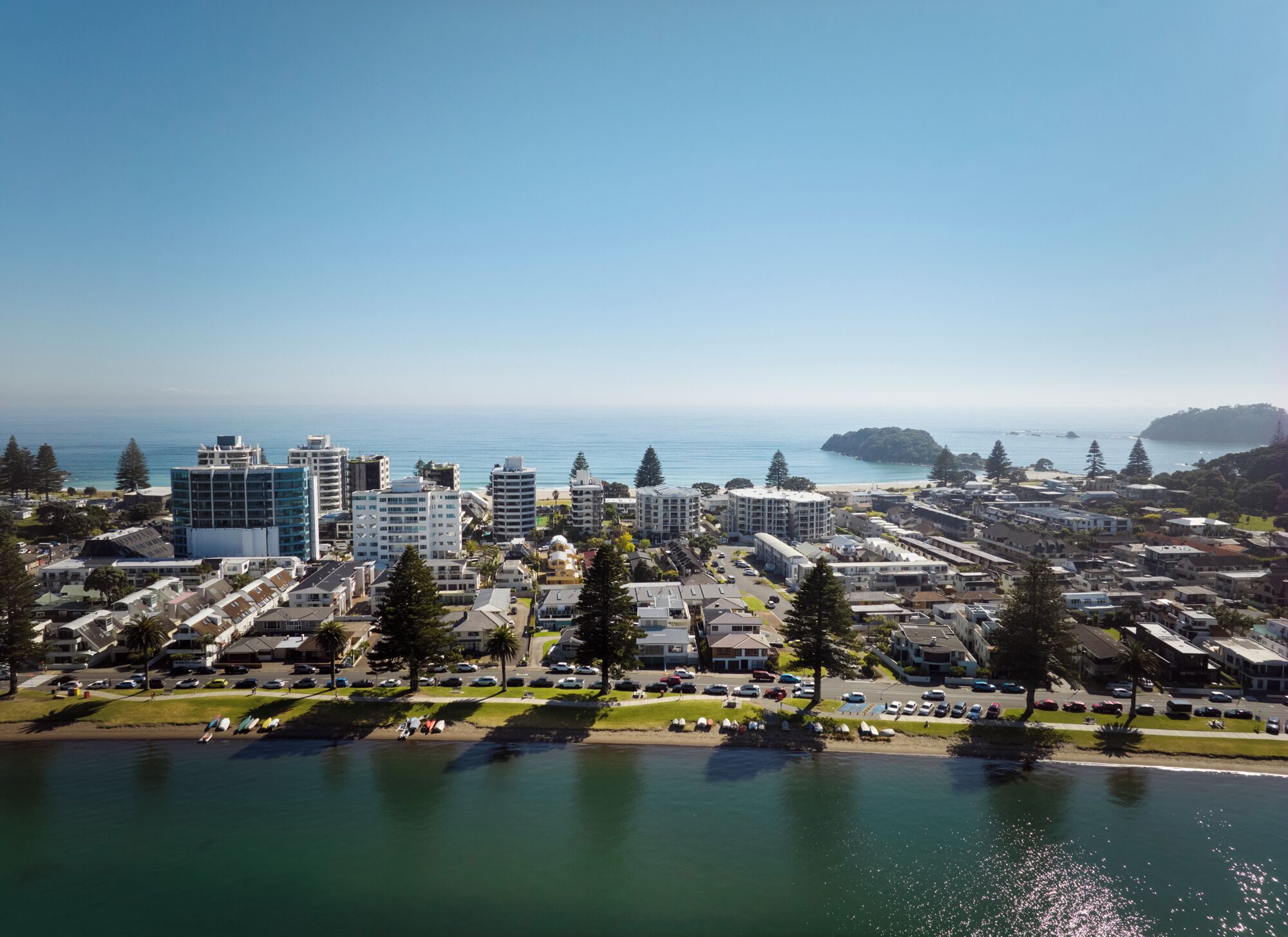 Un paisaje urbano costero con rascacielos, un puerto deportivo y una vista despejada del océano.