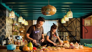 Una cocina con encimera de madera, luces decorativas colgantes y diversos utensilios de cocina.