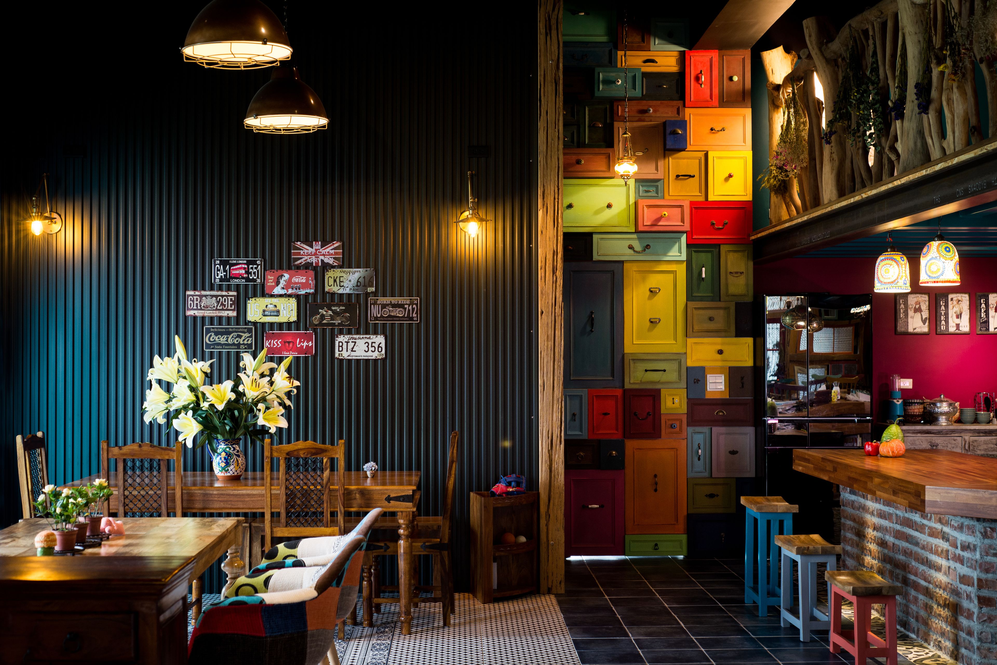 Un restaurant doté d’un bar, de tables et de chaises en bois, ainsi que d’un mur coloré agrémenté de boîtes de rangement.