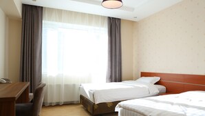 A hotel room with two beds, a wooden desk, and a chair. - Mount Bogd Apartment (Ulaanbaatar)