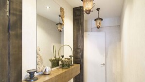 A hallway with a wooden counter, wicker baskets, and a white door. - Mount Bogd Apartment (Ulaanbaatar)