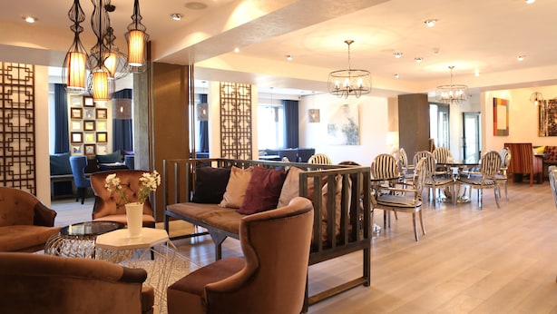 A spacious lobby with a seating area, a dining setup, and decorative lighting. - Mount Bogd Apartment (Ulaanbaatar)