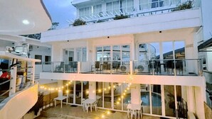 A multi-level hotel with outdoor seating areas and a pool. - Arkipelago Divers and Beach Resort (Puerto Galera)