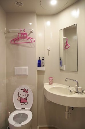 A bathroom with a white toilet, a sink, and a mirror. - Elephant House Boutique Hotel (George Town)