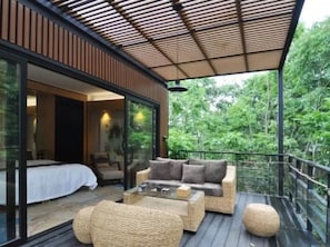 A modern outdoor living space with a glass-enclosed bedroom, a sofa set, and a wooden deck. - Lin Jia Camping Site Shanghai (Shanghai)