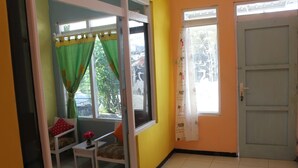 A room with a window, a door, and a chair.