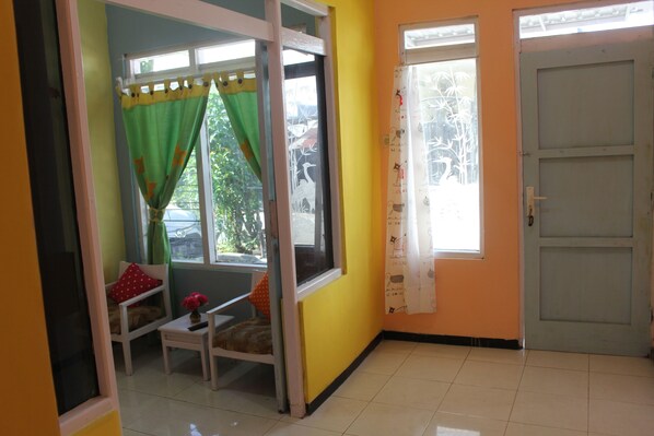 A room with a window, a door, and a chair.