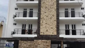A multi-story building with a central vertical section of stone and metal.