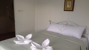 A neatly made bed with white linens and towels arranged in a floral pattern on the bedspread. - Baansuan Keb Tawan Resort (Lop Buri)