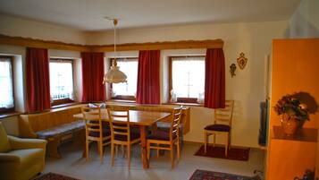 A dining area with a wooden table and chairs, a bench, and a window seat.