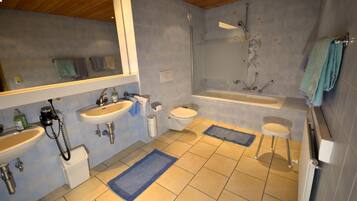 A bathroom with a shower, two sinks, a toilet, and a bathtub.