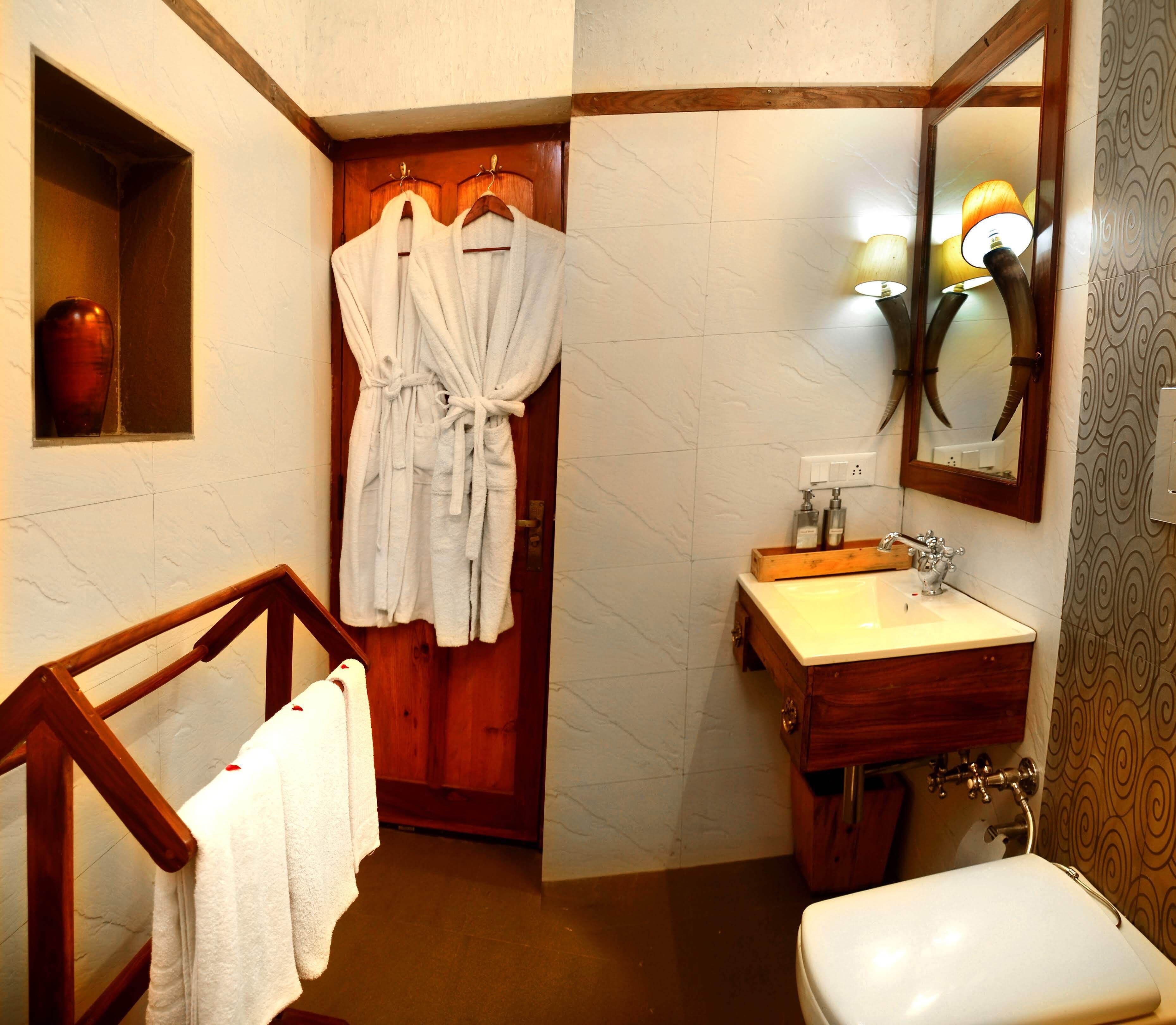 A bathroom with a wooden vanity, a sink, a mirror, and a towel rack.