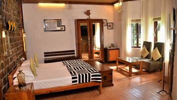 A bedroom with a wooden bed, a wooden nightstand, a bedside table, a chair, a desk, and a window with curtains.
