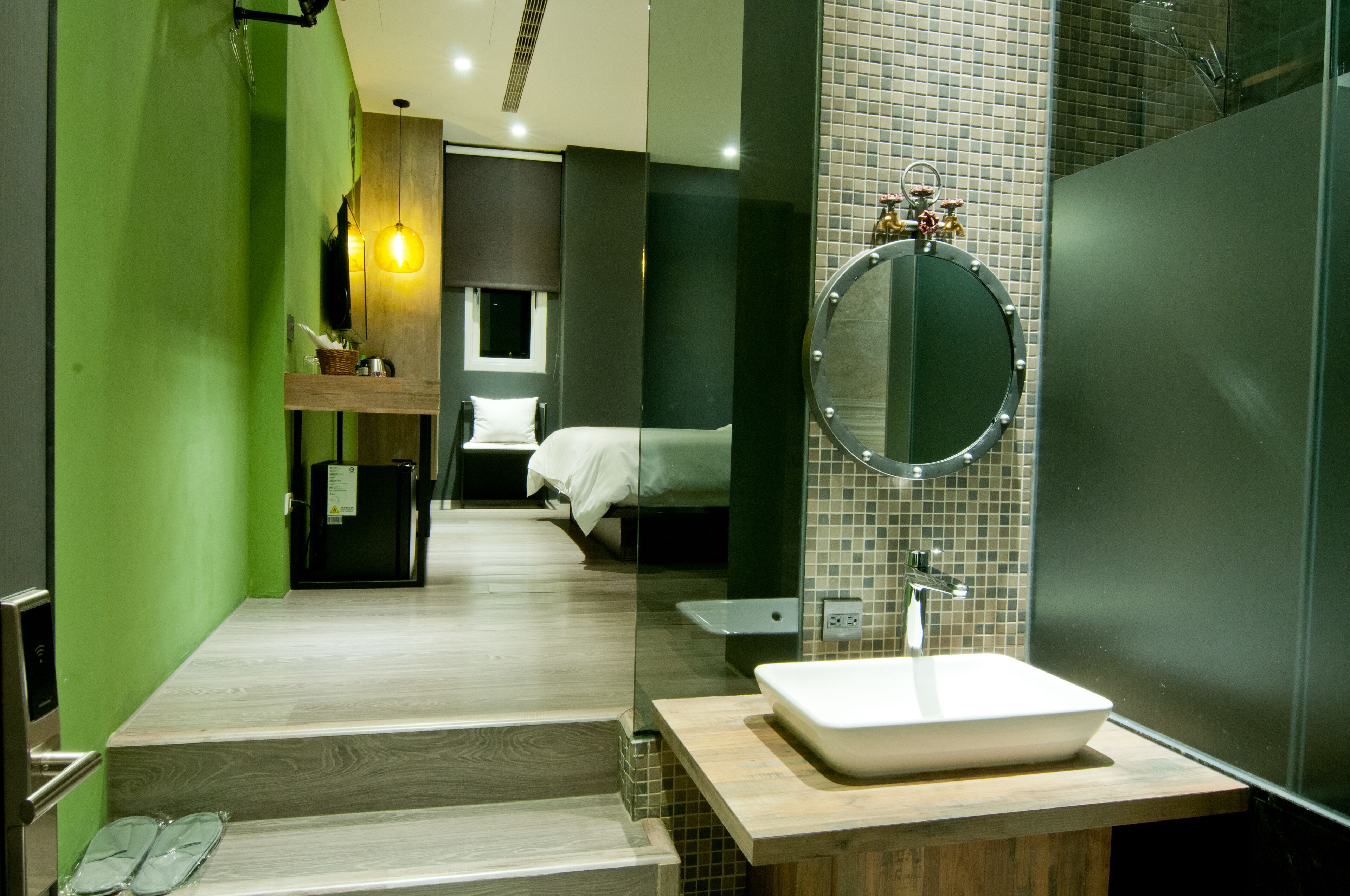 Un baño moderno con un espejo grande, un lavamanos y una zona de ducha.