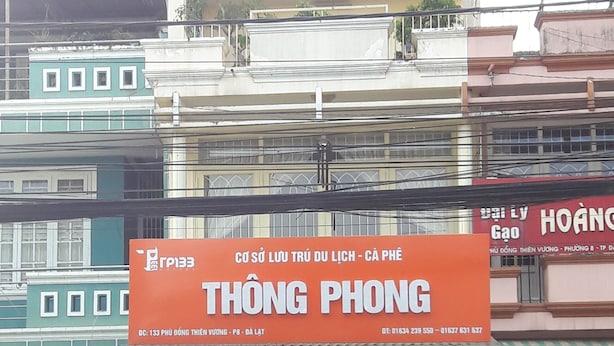 Une devanture de magasin avec une enseigne orange bien visible portant l’inscription « THÔNG PHONG » et les coordonnées.