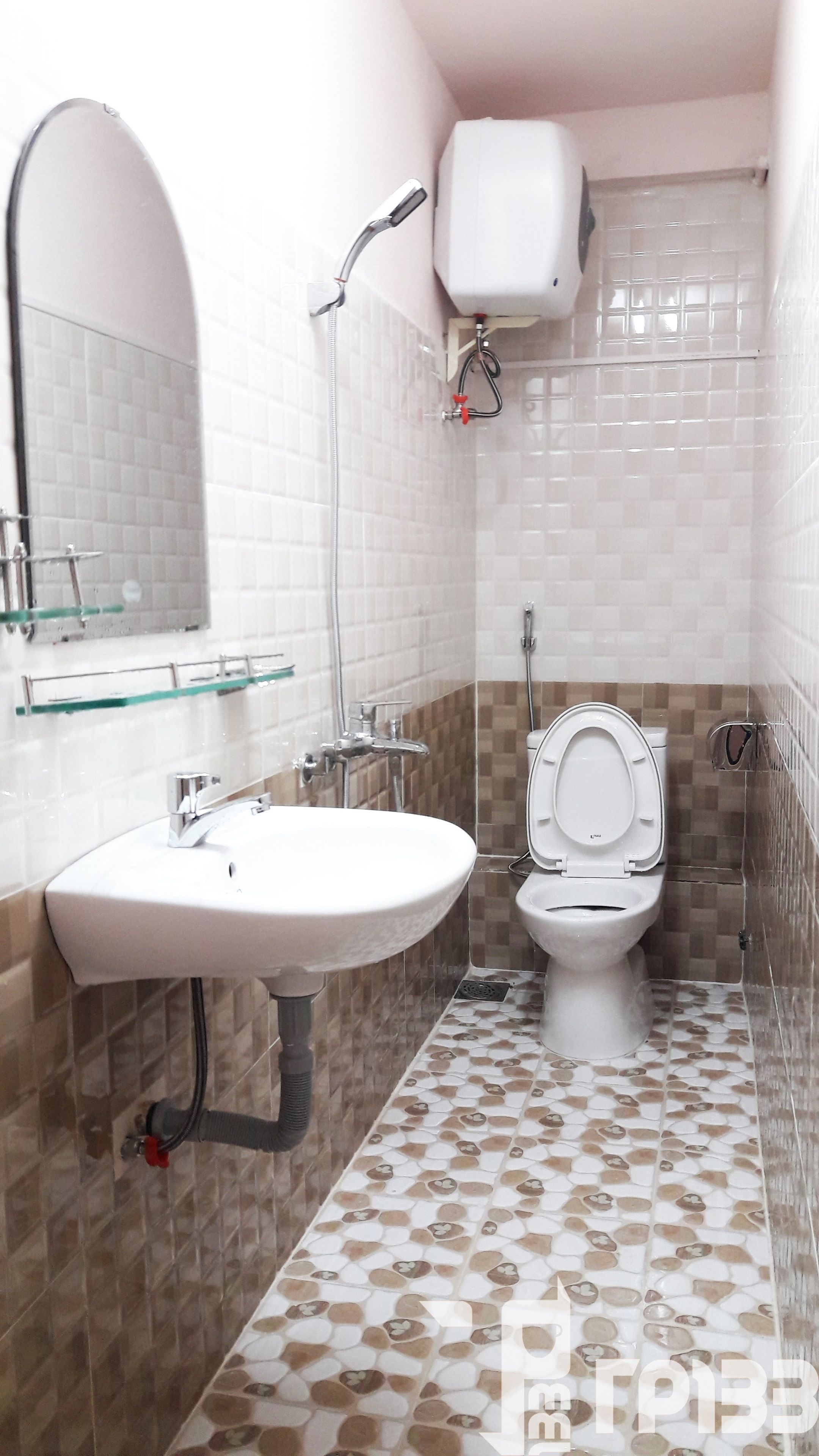 Een badkamer met een wit wastafel, toilet, douche en spiegel.