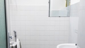Une salle de bain avec des toilettes, un lavabo et un miroir.
