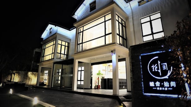 A modern building with large windows and a well-lit entrance. - Mishe TEN Boutique Inn (Shanghai)