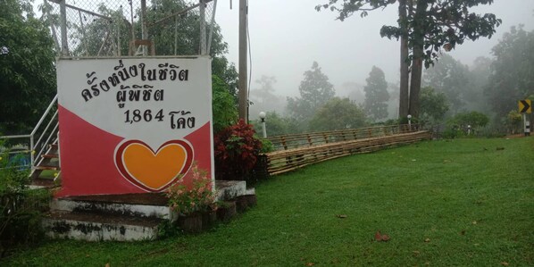 A sign with a heart symbol and text, surrounded by greenery and a wooden fence. - Phuchandang Resort (Khun Yuam)