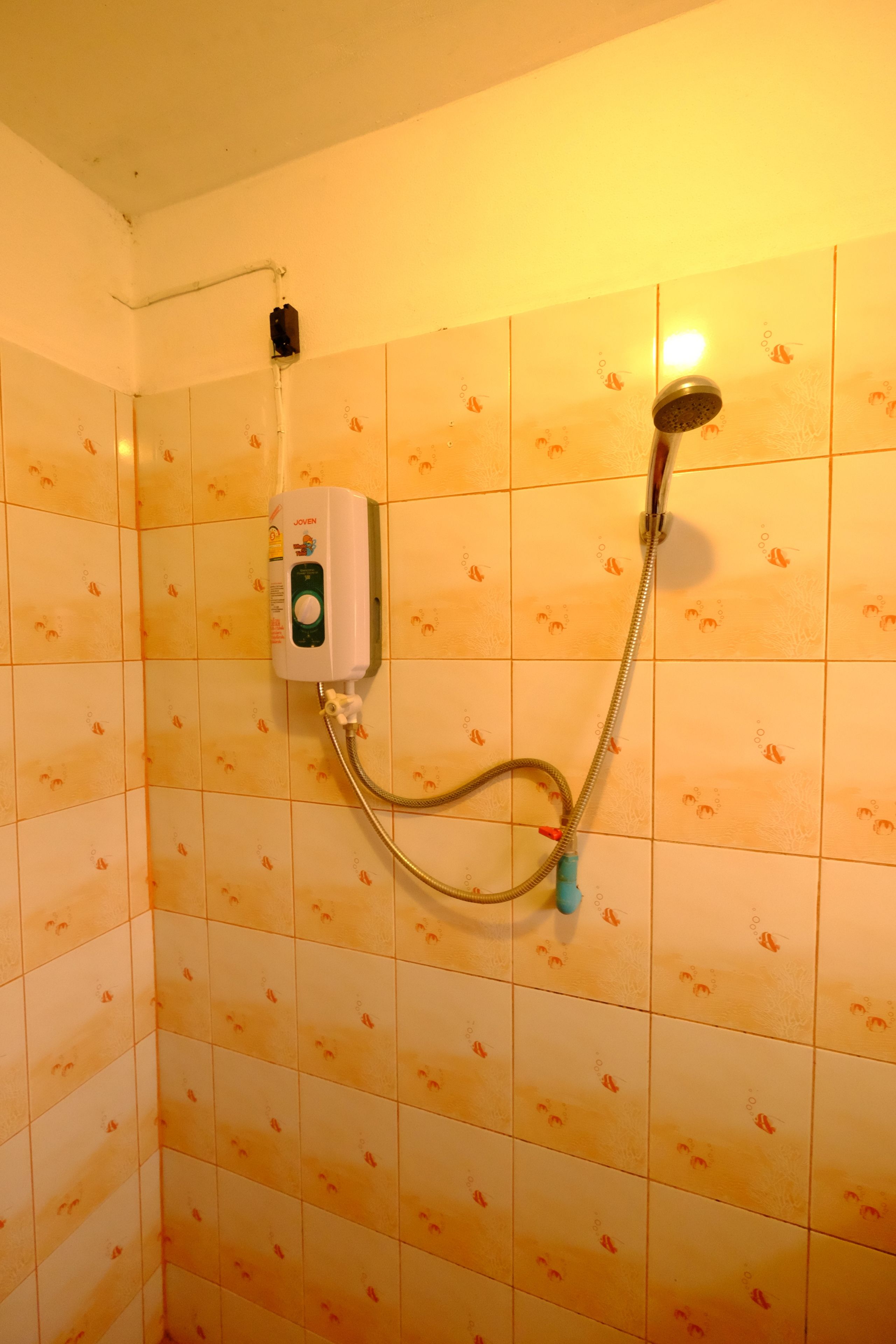 A shower with a handheld showerhead and a control panel mounted on the wall.