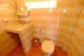 Uma casa de banho com lavatório, sanita e espelho.