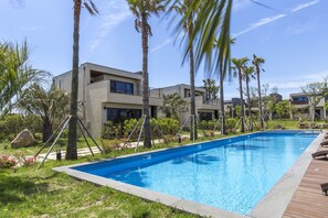 Una piscina al aire libre de temporada, tumbonas