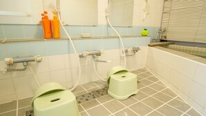 Un baño con dos inodoros verdes, un lavabo y un espejo.