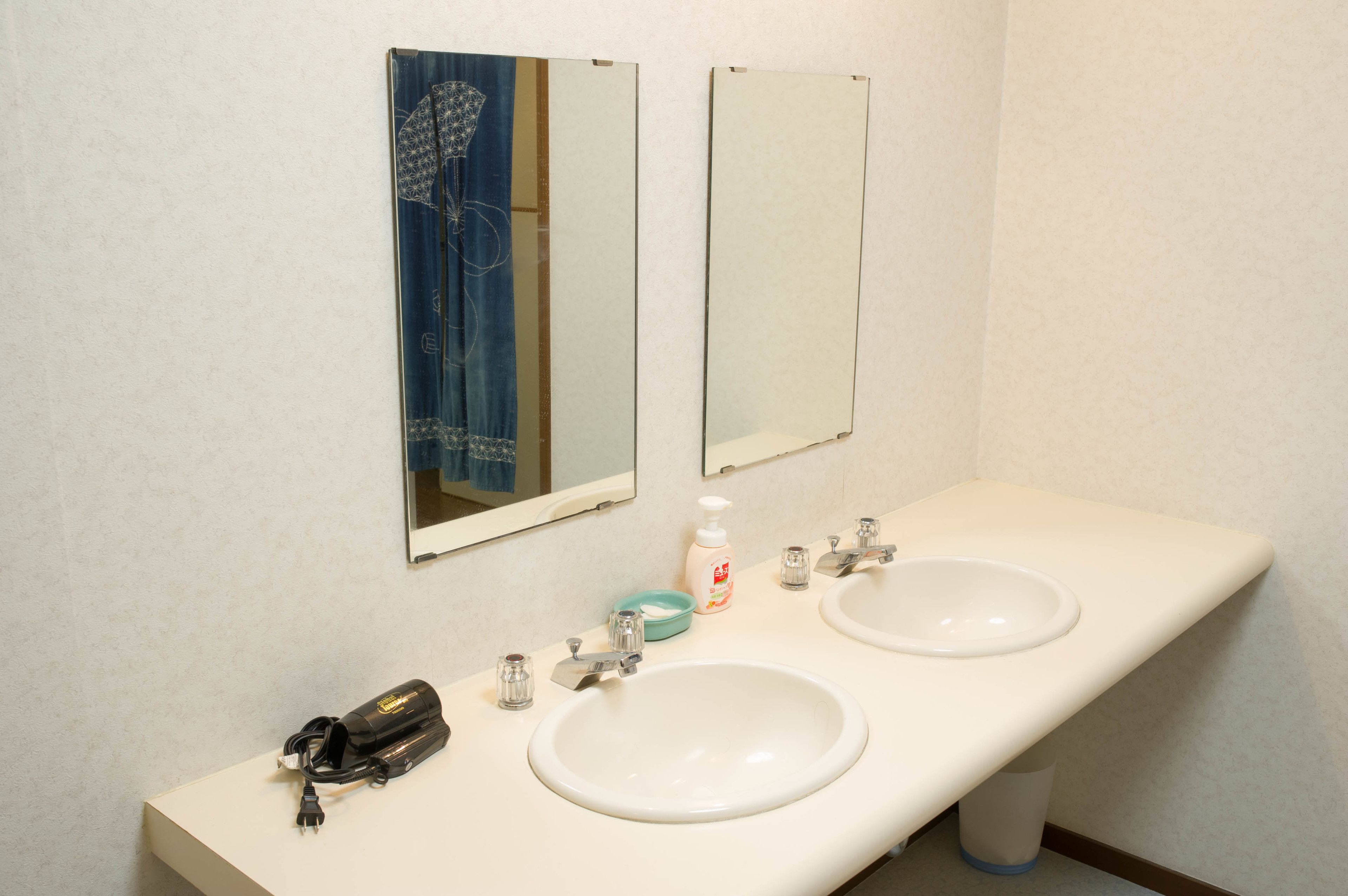 A bathroom with two sinks, a mirror, and a towel rack.