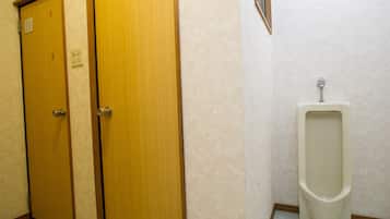A men's restroom with two wooden doors and a urinal.