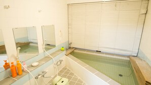 Un baño con bañera, espejos y retrete.