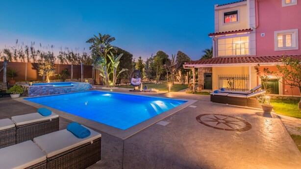 Piscina amb gandules, banyera hidromassatge i zona de terrassa amb sòl de pedra i un dibuix circular decoratiu.