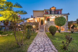 Vista frontal de la propiedad por la tarde o noche