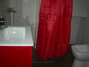 A bathroom with a white sink, a red shower curtain, and a white toilet. - Sweet Home Palio (Kavala)