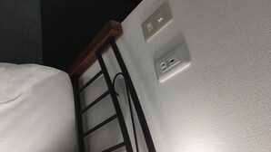 A corner of a room with a bed, a black metal ladder, and a wall socket. - Yadomaru Mine Non Smoking (Mine)