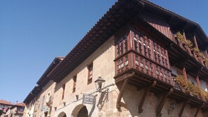 A historic building with stone walls, wooden balconies, and arched doorways. - Posada La Casa del Organista (Santillana del Mar)