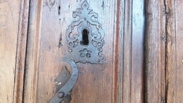 Una puerta de madera con un pestillo de metal y un llamador decorativo.