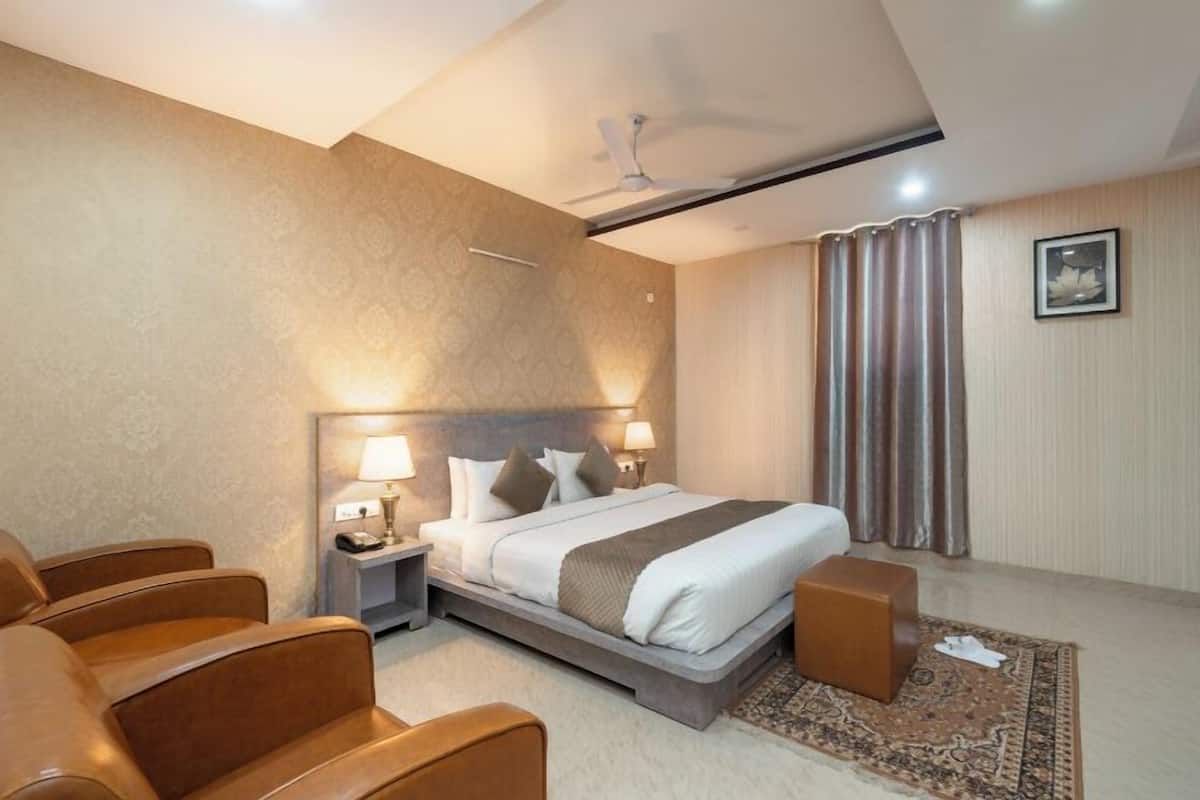Una habitación de hotel moderna con una cama grande, un escritorio y una silla.