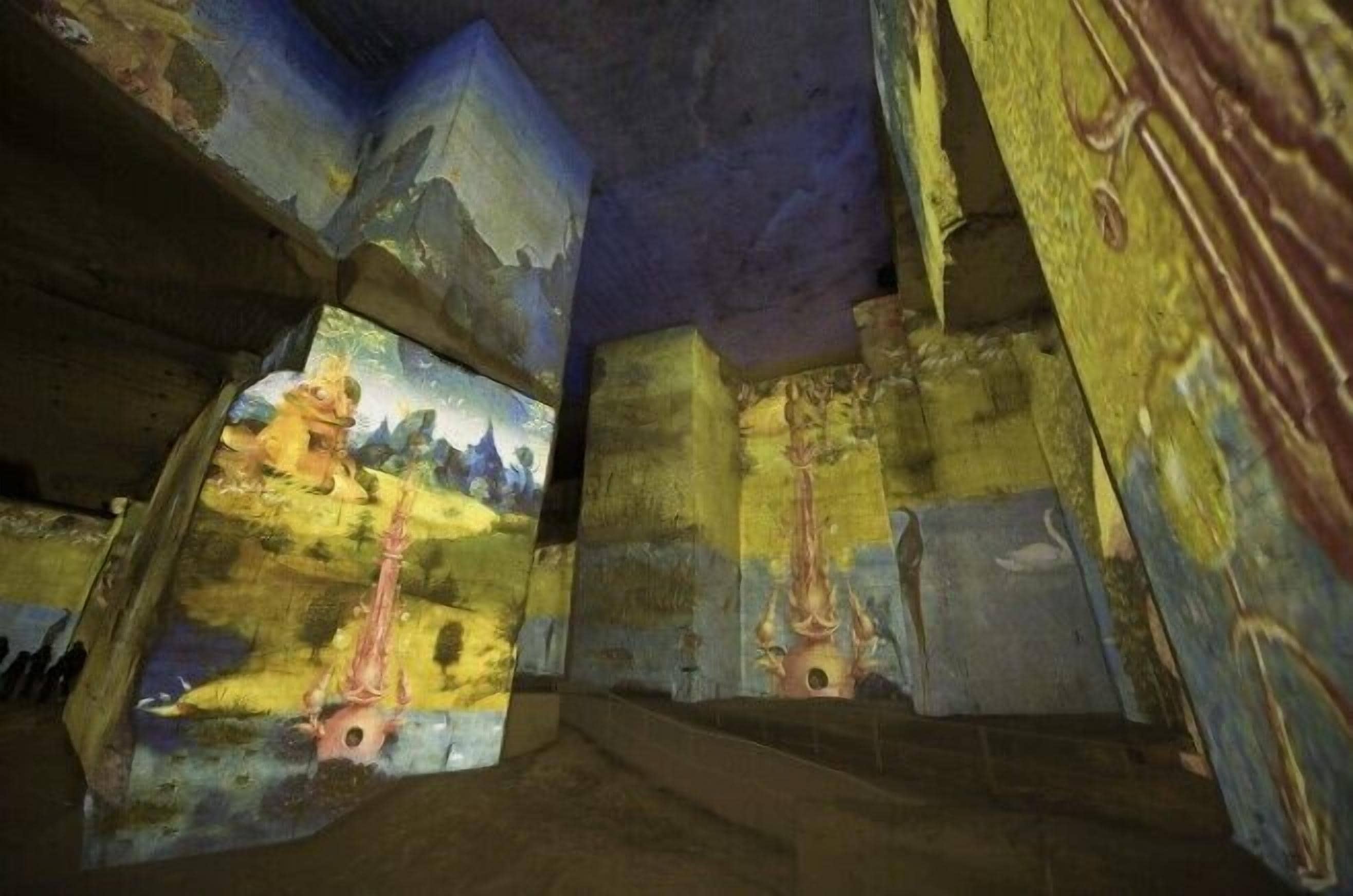 Une pièce ornée d’une fresque représentant un paysage, avec des murs en pierre et une fenêtre donnant sur les montagnes.