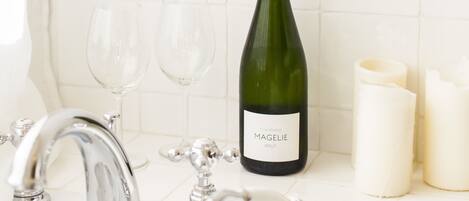 A bathroom with a champagne bottle, two glasses, and candles.