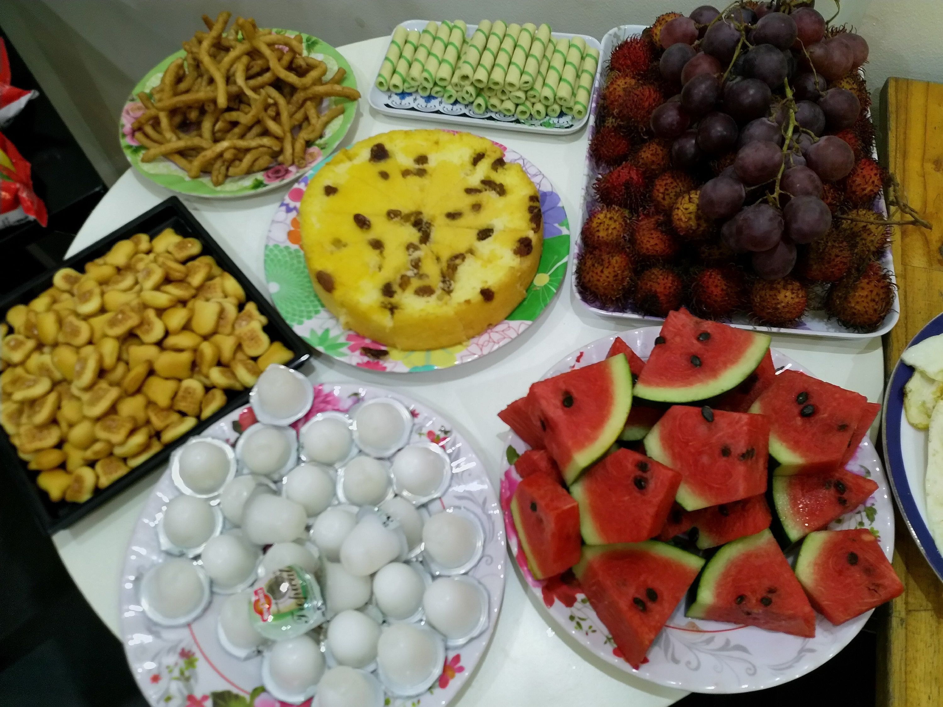 Une table garnie de divers aliments, notamment des fruits, des légumes et des desserts.