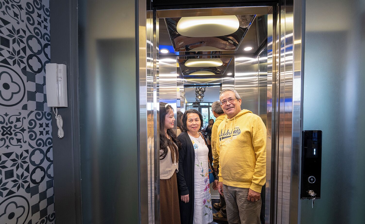 An elevator with metallic walls and a patterned wall design.