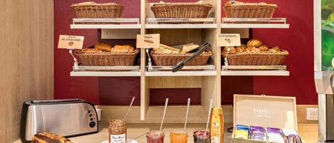 A bakery display with bread and pastries, jars of spreads, and a toaster.