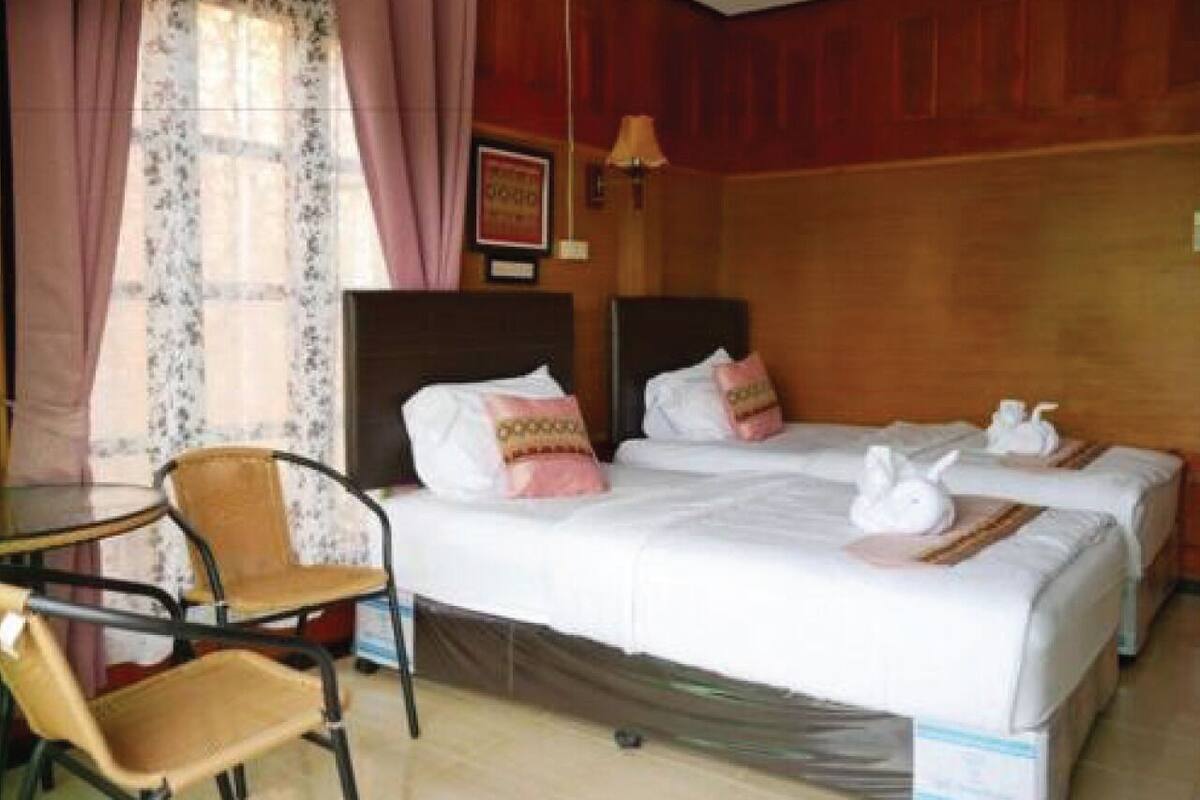 Una habitación de hotel con dos camas, una silla y una mesa.