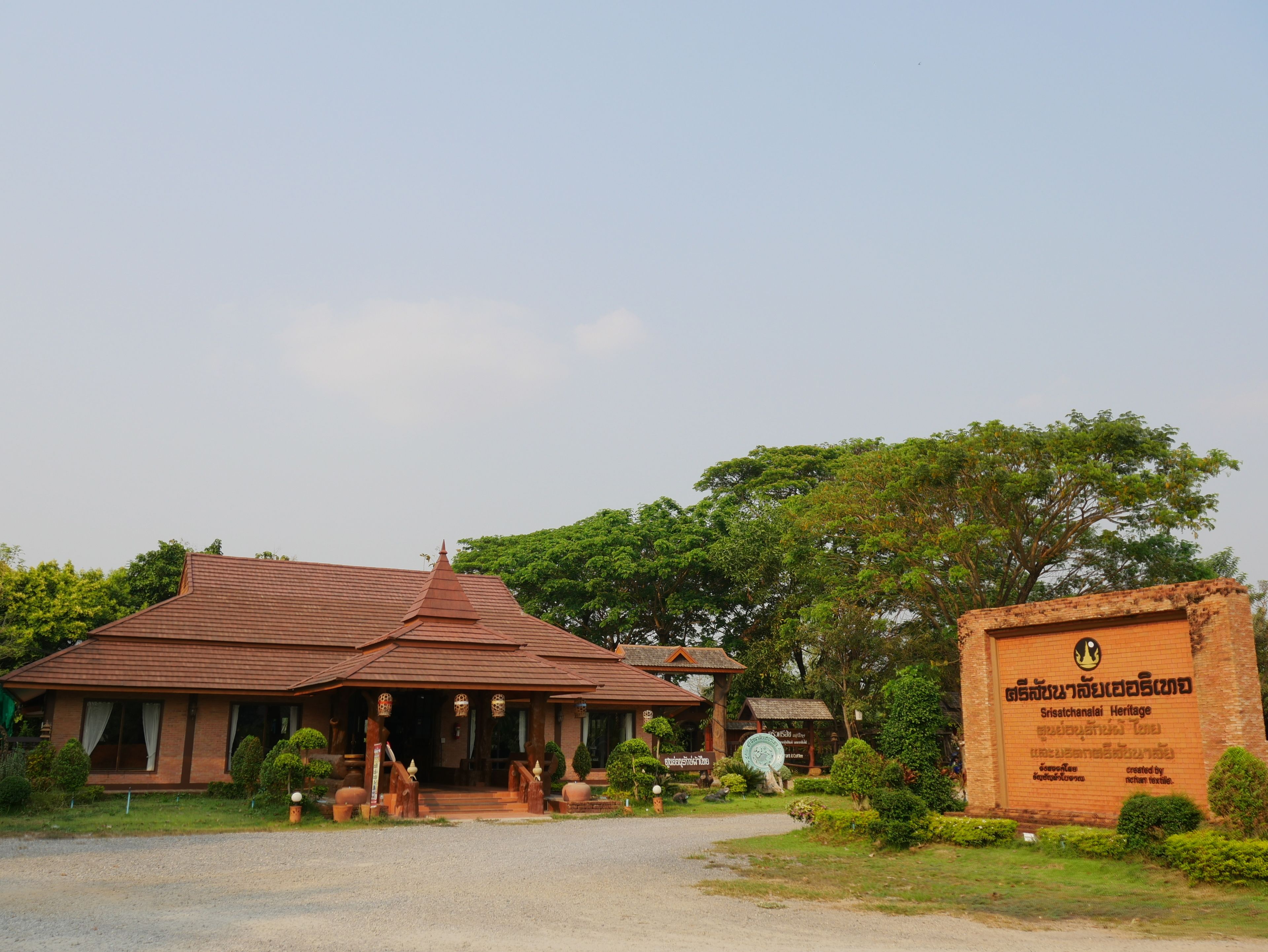 A traditional building with a tiled roof, a signboard, and a well-maintained garden.