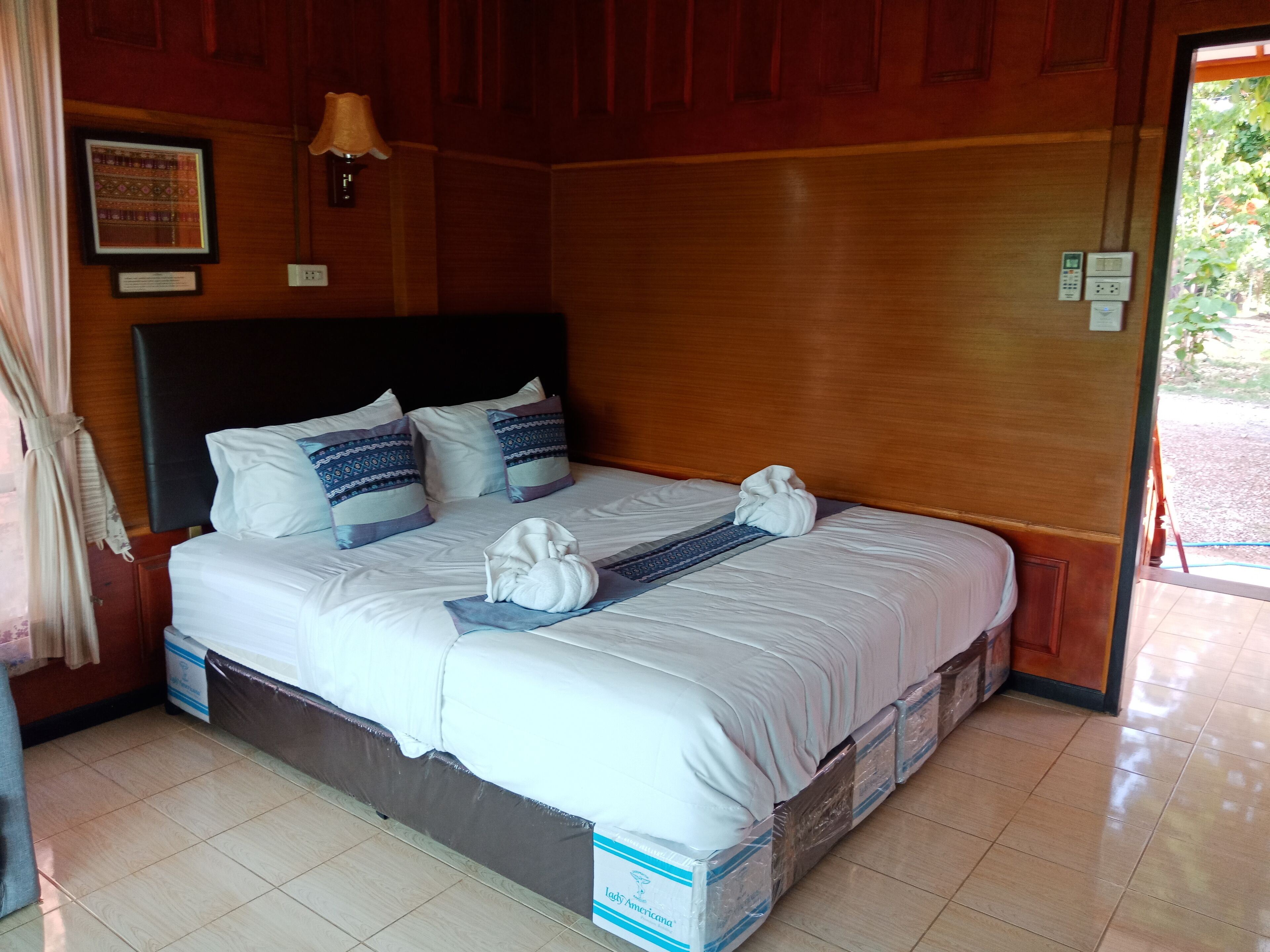A neatly made bed with a headboard, pillows, and a blanket.
