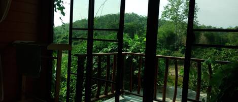 A room with a large window overlooking a lush garden.