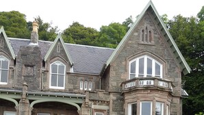 A large stone house with multiple windows and a well-maintained lawn. - Cragowlet House East (Helensburgh)
