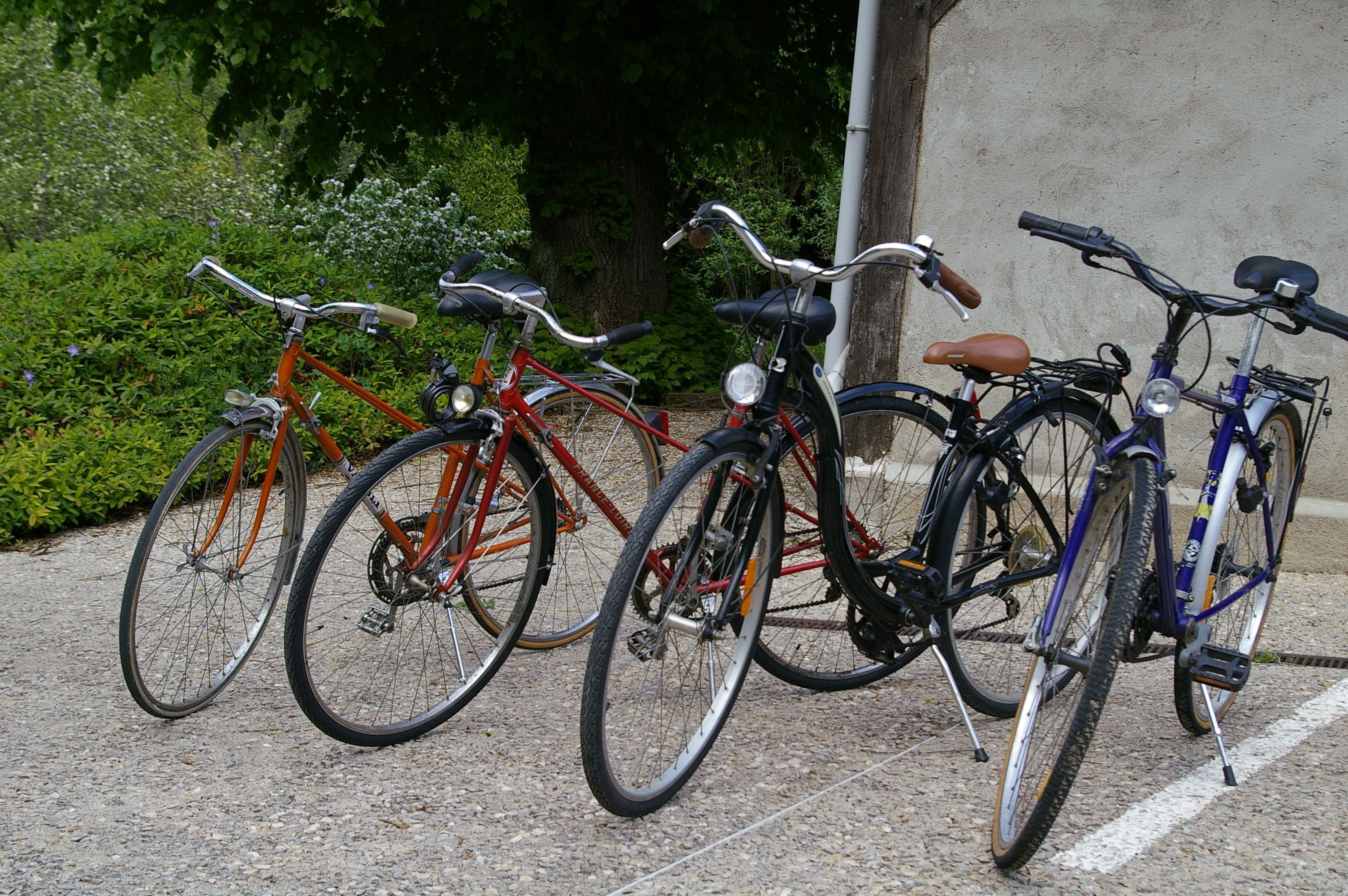 A row of bicycles parked against a wall.