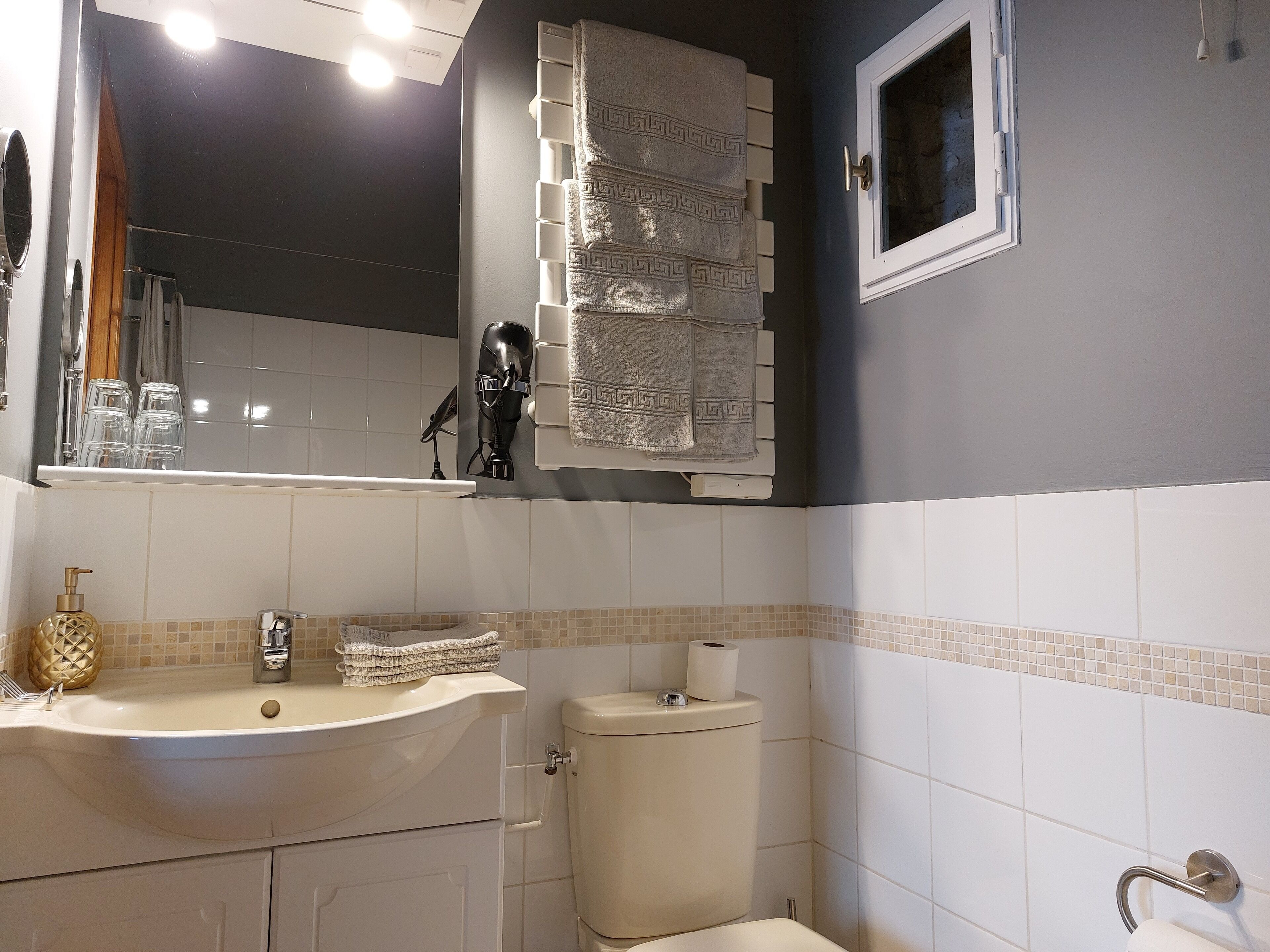 A bathroom with a sink, toilet, and a towel rack.