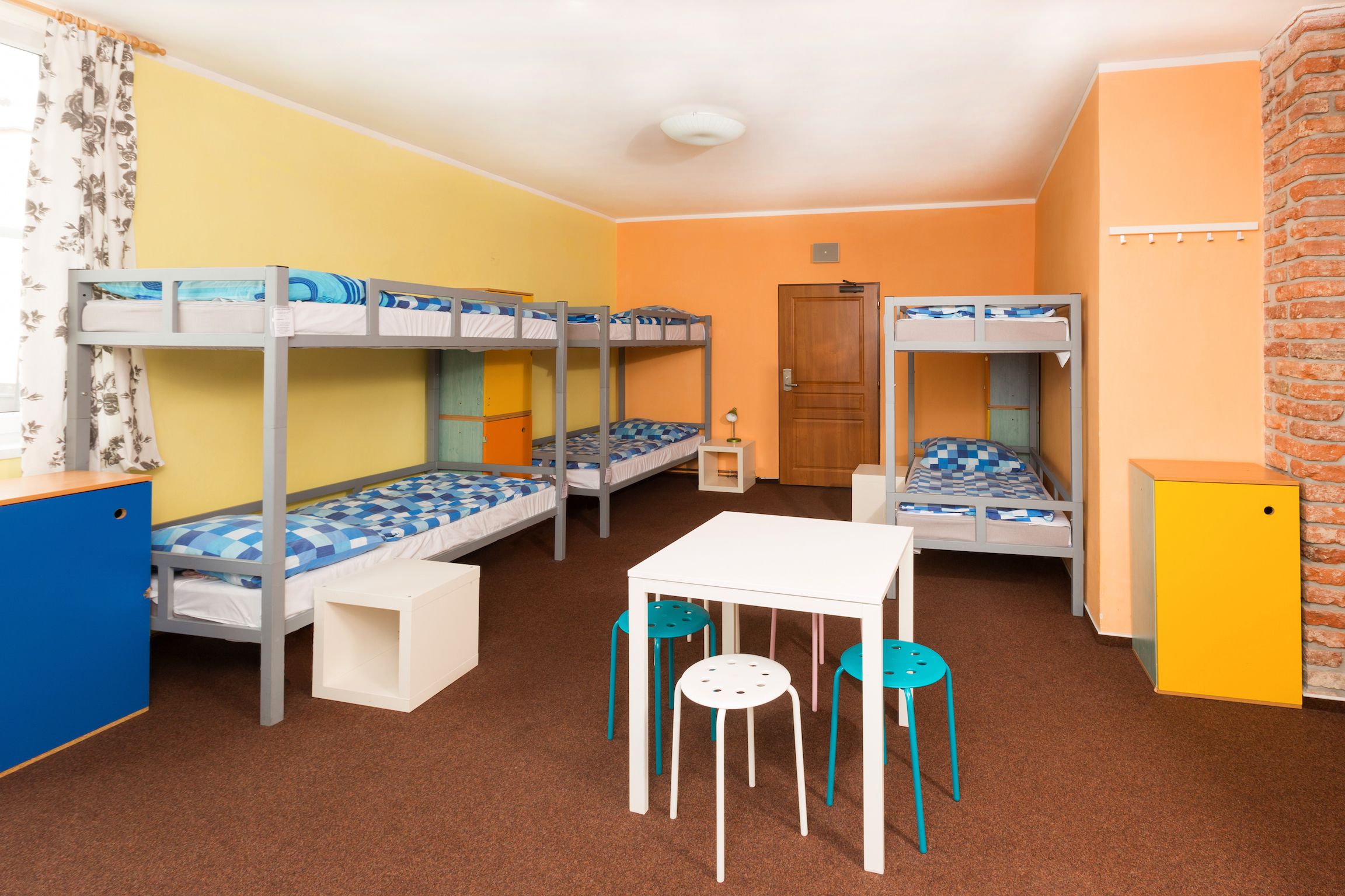 Une chambre de dortoir avec des lits superposés, une petite table, des chaises et un bureau.